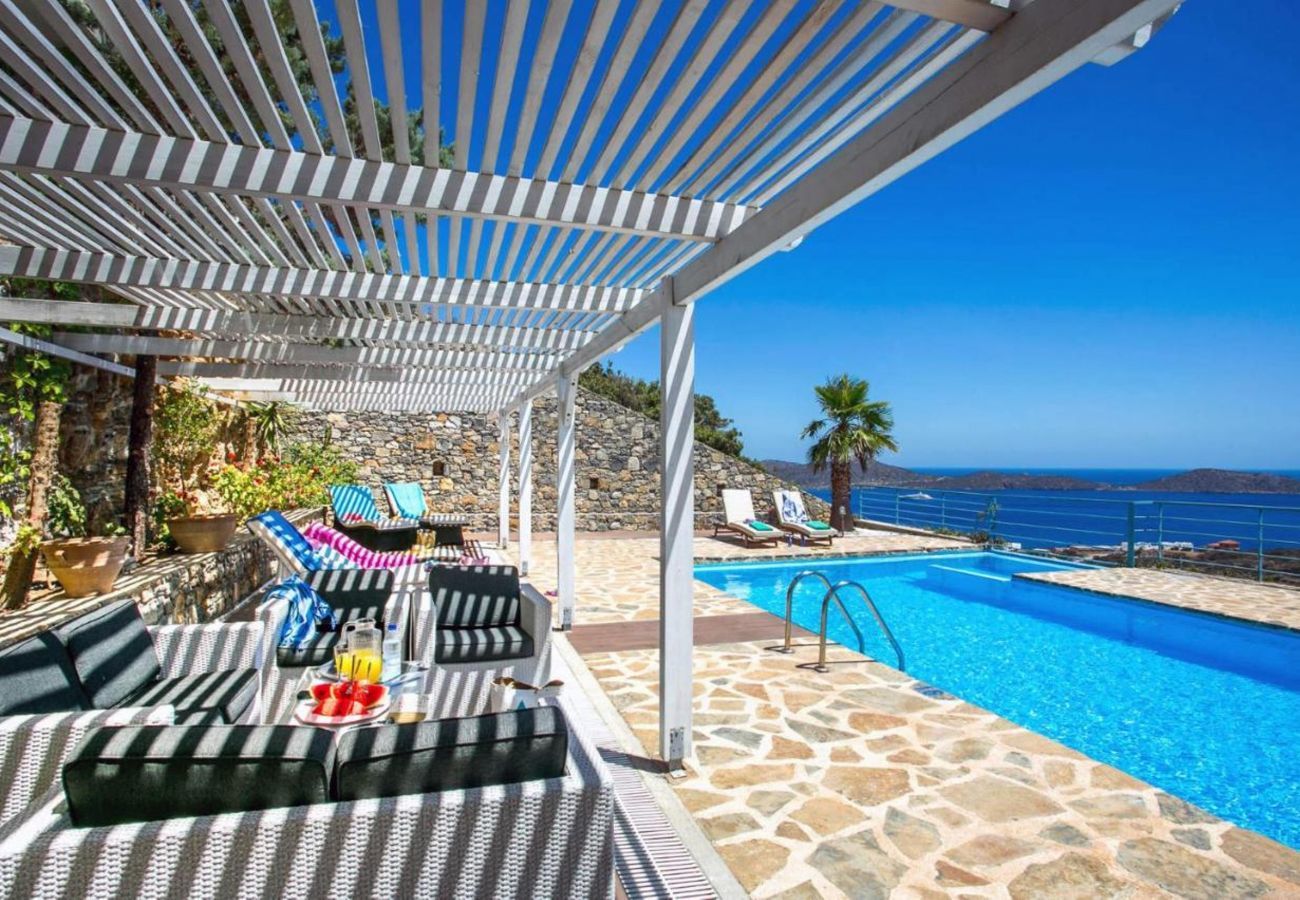 Villa Elounda is een vrijstaande villa met privézwembad en panoramisch uitzicht over de zee op een berg in Elounda, Kreta